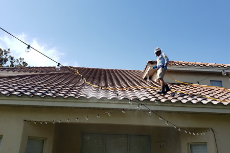 Technician performing soft wash roof cleaning in orlando